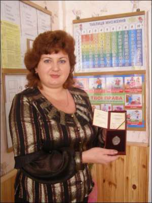 Учительница начальных классов винницкой школы №35 Юлия Олийник показывает награду ”Заслуженный учитель Украины”, которую получила от президента