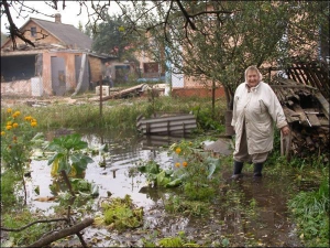 Софія Крутова показує свій город, залитий водою, на вулиці Устинській у Рівному. Вода доходить жінці вище кісточок