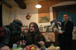 Президент ”Святого сада” Илько Лемко (справа) показывает плакат с музыкантами из английской группы ”Битлз” в кафе ”Вірменка” во Львове. Их музыкой в 1960 годах очень увлекались хиппи