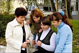 Олена Гурова (у центрі) показує копію виграшного лотерейного білета з печаткою фірми ”МСЛ” подругам та знайомим у райцентрі Тальне Черкаської області