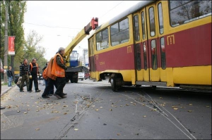 Аварійна бригада з Подільського депо оглядає у четвер на вул. Глибочицькій вагон, який зійшов із рейок, перш ніж ставити його на колію