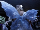 Дівчата в сукнях із крильцями у павільйоні ”Акко Інтернешнл” частують гостей Тижня моди шампанським