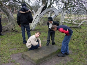 Дети из города Кролевец на Сумщине рассматривают яблоню-колонию и надмогильную плиту князю Мещерскому