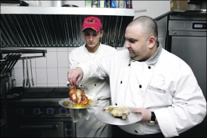Владелец и шеф-повар столичных кафе-баров авторской кухни ”Кушавель” Олег Шейнкер проверяет на готовность свиную рульку. Порции блюд в его заведениях большие