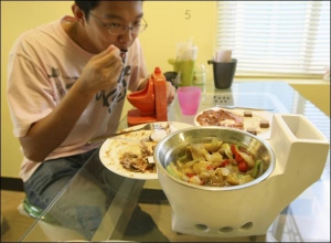 Відвідувач китайського ресторану, стилізованого під вбиральню, куштує страву з посудини-унітаза. За стільці в закладі слугують справжні унітази
