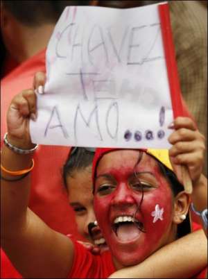 Венесуэлка держит плакат „Чавес, мы тебя любим!” на митинге в Каракасе, который собрали в честь 10-летия президентства Уго Чавеса