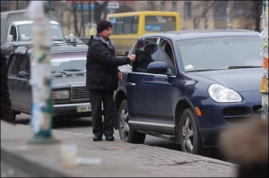 Клиент садится покупать доллары в ”Порш Кайен”. Машина припаркована перед рынком на Севастопольской площади Киева. В настоящее время валютные менялы работают в машинах