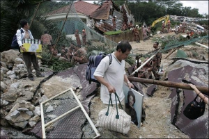 Жители малайзийской столицы Куала-Лумпур спасают ценные вещи из-под завалов своих домов