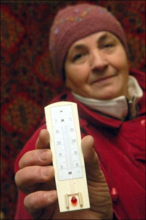 Киянка Тетяна Гнатовська міряє температуру у своїй квартирі на вулиці Героїв Сталінграда. Термометр показує 15 градусів