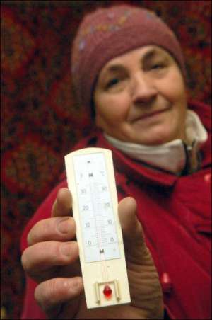 Киевлянка Татьяна Гнатовская меряет температуру в своей квартире на улице Героев Сталинграда. Термометр показывает 15 градусов
