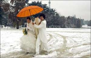 Молодые после венчания прогуливаются по заснеженным улицам Милана. Из-за снегопадов в городе фактически не работает общественный транспорт