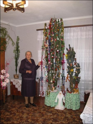 Ніна Яківна Дробиш із села Мошни на Черкащині біля кактусів. Жінка кілька років наряджає їх до новорічних і різдвяних свят. Цьогоріч прикрасила рослини на тиждень раніше