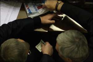 Народный депутат от Партии регионов Юрий Колоцей (справа) и его коллега (держит в руке 100-долларовые купюры) разговаривают во время заседания парламента