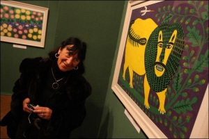 Киевская художница Нелли Юсупова фотографирует работы Марии Примаченко. Она лепит глиняных зверят по мотивам ее творчества