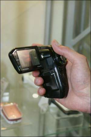 Представник компанії ”Медіа Бум” показує дорожню флеш-відеокамеру компанії ”Саньйо” під час виставки ”Діджі Фото Шоу-2008”. Новинка має десятикратне оптичне збільшення і функцію розпізнавання облич