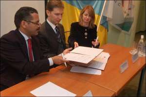 Рональд Ноубл (ліворуч), Олександр Васильєв та Елен Дезінські підписують Меморандум про створення електронних паспортів для Інтерполу в консорціумі ЄДАПС