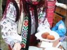 Участница фестиваля пампушек выкладывает горячую сдобу из кипящего масла на пластиковую тарелку