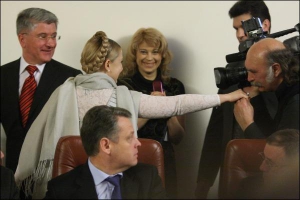 Прем’єр-міністр Юлія Тимошенко вітається з одним із телеоператорів перед учорашнім засіданням уряду. Поруч стоять її прес-секретар Марина Сорока та міністр Кабміну Петро Крупко