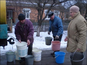 31 січня Іван Секалюк (у центрі) із сусідами набирають у відра й бідони чисту воду. Її привозять цистерною  з місцевого водоканалу у центр Турбова Липовецького р-ну
