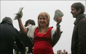 Алина Айвазова, жена мэра столицы Леонида Черновецкого, держит доллары, выигранные на тотализаторе одним из зрителей на Киевском ипподроме. Там состоялись первые соревнования на Кубок мэра Киева