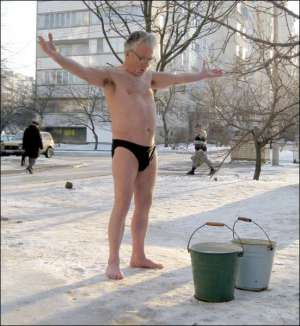 Валерій Маснюк обливається холодною водою у подвір’ї свого будинку в Черкасах