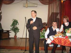  Анатолій Волошин (з мікрофоном)  виступає на презентації збірки поета Леоніда Даценка (сидить праворуч) у ресторані ”Тарантела” в Черкасах