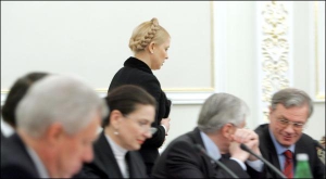 Премьер-министр Юлия Тимошенко идет на свое место перед началом заседания Совета национальной безопасности и обороны. За столом сидят нардеп от ”Регионов” Инна Богословская и уполномоченный президента по международным вопросам энергетической безопасности 