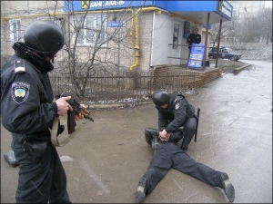 Инспектор государственной службы охраны Дмитрий Ильчук задерживает грабителя банка на улице Туполева, 26 в Донецке. Другой инспектор Николай Пашко стоит на страже