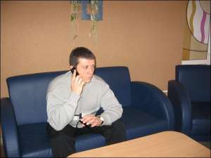 Александр Иващенко разговаривает по мобильному телефону в холле телерадиокомпании ”Рось”