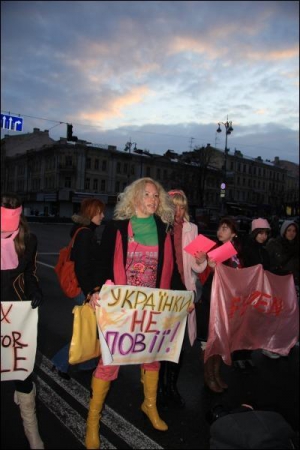 Студентка Анна Мухіна тримає плакат ”Українки не повії!” 1 березня на Хрещатику. Дівчина — колишня учасниця телешоу ”Фабрика зірок-2”