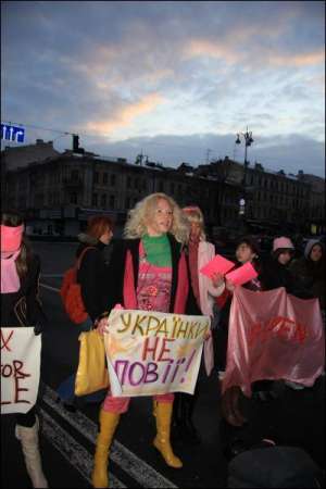 Студентка Анна Мухина держит плакат ”Украинки не проститутки!” 1 марта на Крещатике. Девушка — бывшая участница телешоу ”Фабрика звезд-2”