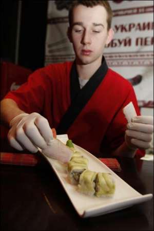 Сушист столичного ресторану-клубу ”Калинка-малинка” Валерій Ковальчук прикрашає роли з салом зеленою цибулею. Він готує шість видів національних суші