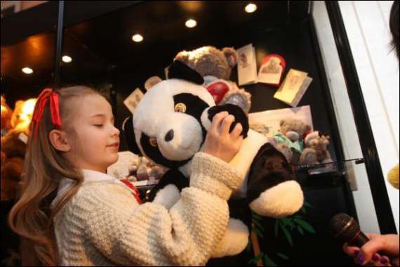 Посетительница выставки ”Все о мишках” в столичним Музее игрушек переворачивает панду. Мишка сопит и ворчит