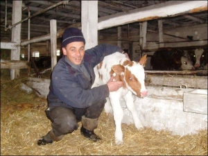 Телятник Николай Педько обнимает суточного бычка на ферме в селе Плешкани Золотоношского района. Животные узнают его сразу же, как заходит в помещение, и ждут, пока мужчина их накормит