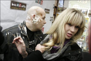 Писатель Олесь Бузина и 20-летняя Александра Шевченко через несколько секунд после инцидента в книжном магазине. Александру держит за плечо директор книжного магазина