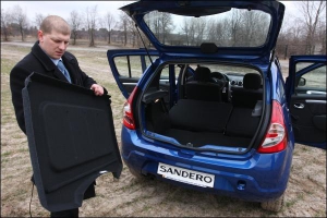 Менеджер Олег Никитюк складывает задние сидение, чтобы увеличить объем багажника. Это позволяет перевозить крупногабаритный груз