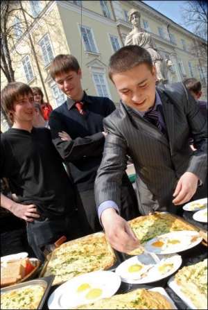 Студенты пробуют яичнцу на львовской площади Рынок во вторник, 7 апреля. Кроме приготовления блюда из 1500 яиц, организаторы мероприятия провели конкурс на самое быстрое поедание яичнцы. Победитель съел пять яиц за минуту и шесть секунд