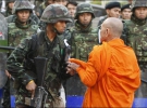 Буддийский монах успокаивает солдат, подавлявших с оружием в руках акции протеста в Бангкоке