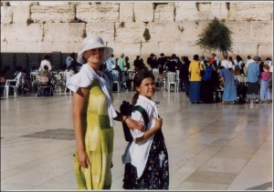 14-річна Олександра Тімоніна з мамою Тетяною під час першої своєї поїздки в Єрусалим 2003 року. Туристи сфотографувалися біля Стіни Плачу. У стіні Олександра залишила свою записку із проханням до Бога про  народження братика чи сестрички