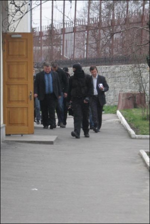 Работники СБУ ведут Анатолия Пархету к помещению суда после обыска его автомобиля. Мужчину задержали по подозрению в получении взятки в размере тысячи долларов
