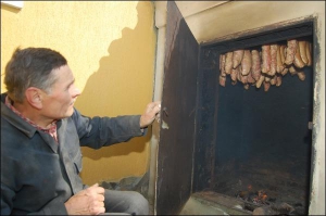 Степан Мацько у вівторок зранку коптить ковбасу і шинку на обійсті сусіда Теодозія Шпика у селі Куликів Жовківського району на Львівщині