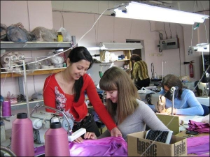 В производственном цехе владелица фирмы ”Эллен стайл” Елена Самигулина (слева) показывает швее, как нужно строчить накладную ленту на воротнике блузы