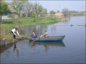 Працівники Золотоніської насосної станції виловлюють підсаками загиблу рибу, щоб вона не потрапила в насос, а потім — у Кременчуцьке водосховище