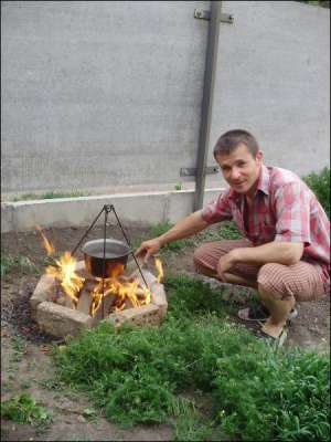 Мирослав Доненко около собственного дома в Каменке собирается варить кашу на костре. Будет угощать кумовьев. Говорит, что нигде нет такой вкусной каши, как дома