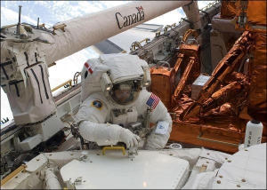 Астронавт Джон Грансфельд порається біля космічного телескопа ”Хаббл”. 19 травня він пробув у відкритому космосі 7 годин 2 хвилини