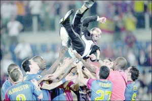 Игроки ”Барселоны” подбрасывают тренера Хосепа Гвардиолу. Он выиграл три трофея — Лигу чемпионов, чемпионат и Кубок Испании, — в первый же год своей работы