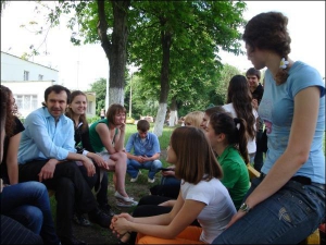 Солист группы ”Океан Ельзы” Святослав Вакарчук разговаривает со студентами-волонтерами в парке возле детского приюта на улице Белецкой в столице