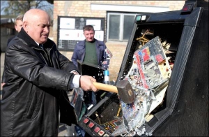 Заступник директора столичної бази конфіскованих гральних автоматів Віталій Іващенко розбиває молотом нелегально встановлений автомат. 23 жовтня 2008 року