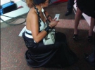 Певица Маша Фокина вынимает из сумочки папиросы ”Вог” у дверей дворца