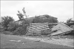 Разрушенная 11 июня ураганом крыша дома в райцентре Любешов Волынской области. Рядом лежат несколько сломанных буревалом деревьев